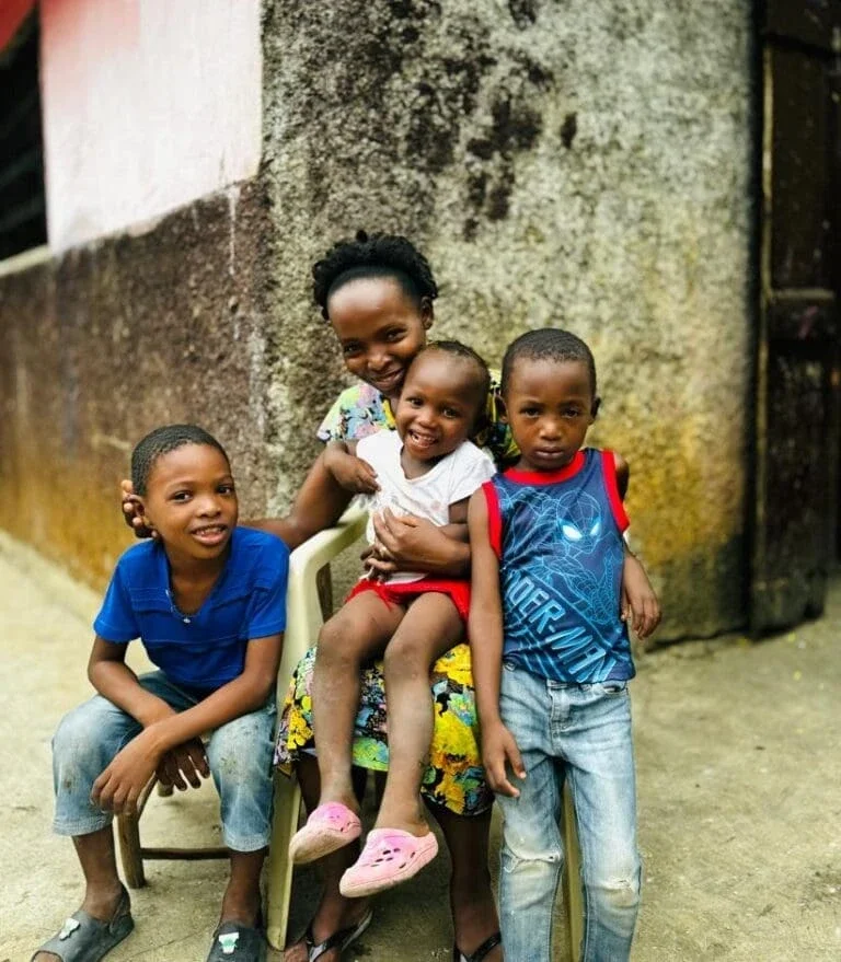 A family in Haiti awaits installation of the mesh grid (Photo Courtesy of Alina Enèji)